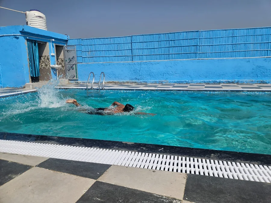 Guest swimming in pool at Clyrova Farmhouse Jaipur